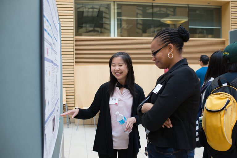 Camy Leung presents her poster to Rolinda Carter, PhD Student in Ed Pryzdial Lab