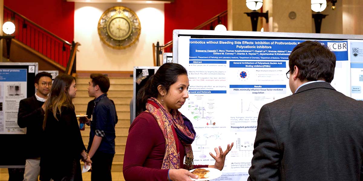 Poster presenter speaking with attendee at the Earl W. Davie Symposium, a major CBR symposium and annual CBR event