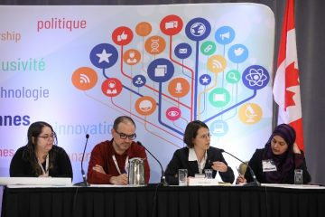 In 2018, Dr. Kate Sedivy-Haley (second from right) attended the 10th Canadian Science Policy Conference. She shared her workshop group’s position on pollution in a “Science Policy 101”. Dr. Sedivy-Haley is speaking into the microphone; there is a Canadian flag in the background.