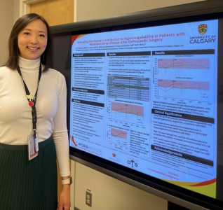 Lisa Yamaura stands next to her winning poster, which was voted as the best virtual poster at the Norman Bethune Symposium 2022
