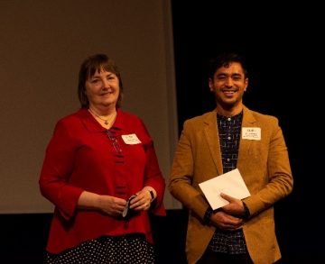 Poster winner Pranav Shrestha (right) on stage to receive his prize for the best in-person poster at the Norman Bethune Symposium 2022 from Dr. Dana Devine (left)