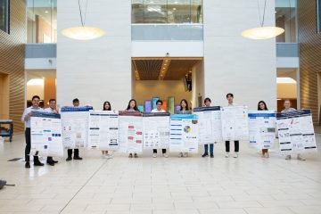 Summer students holding their posters in the Life Sciences Centre West Atrium