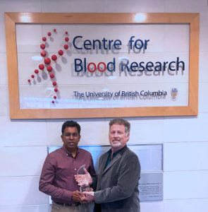 Rodney Staff (right) presents Dr. Jayachandran Kizhakkedathu (left) with the Organ Transplant Innovation and Research Team Award 2021